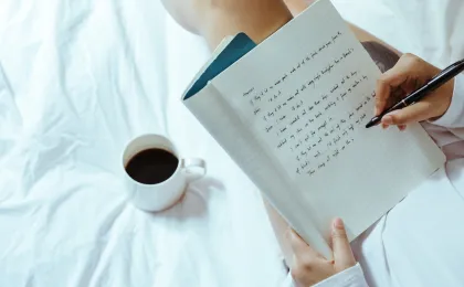 Escribiendo un texto en la cama con cafe